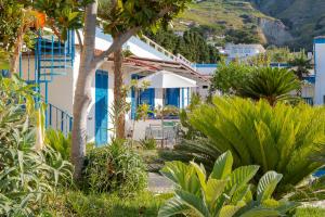- une vue sur une maison ornée d'arbres et de plantes dans l'établissement Hotel Casa Adolfo Ischia, à Ischia