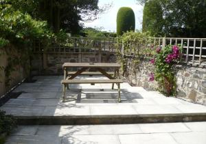 a wooden picnic table sitting on a stone patio at Larch Cottage in Craster