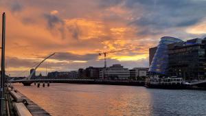 einen Sonnenuntergang über einem Fluss in einer Stadt mit Gebäuden in der Unterkunft City Nest. in Dublin