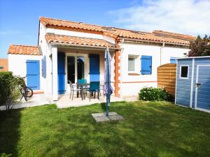 uma pequena casa branca com portas azuis e um quintal em Charmante maison de vacances, 4P, piscines, proche Gohaud em Saint-Michel-Chef-Chef