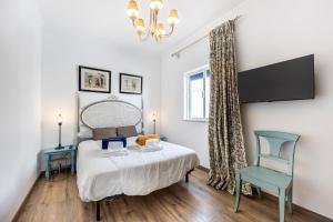 un dormitorio con una cama y una silla en Casa Albardeira 1 by Seewest, en Lagos
