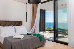 um quarto com uma cama e vista para o oceano em Luxury Villa Ander with Pool em Kostrena