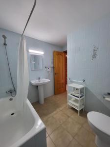 y baño con lavabo, bañera y aseo. en Apartamentos Mar Bella en Es Cana