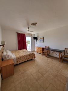 a bedroom with a bed and a table and a desk at Apartamentos Mar Bella in Es Cana