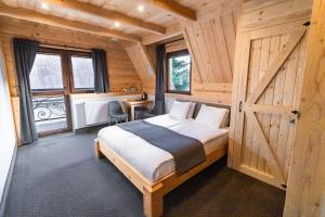a bedroom with a bed in a wooden cabin at Chocholowska Zohylina pokoje i domek in Chochołów