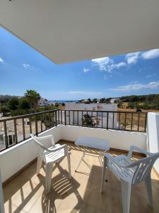a balcony with two chairs and a table at Apartamentos Mar Bella in Es Cana
