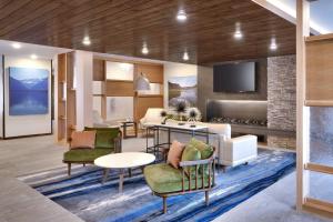 a living room with a couch and chairs and a tv at Fairfield Inn & Suites by Marriott Livingston Yellowstone in Livingston