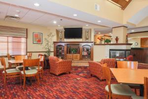 um restaurante com mesas e cadeiras e uma televisão de ecrã plano em Residence Inn by Marriott Flint Grand Blanc em Flint