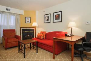 sala de estar con sofá rojo y chimenea en Residence Inn by Marriott Flint Grand Blanc, en Flint