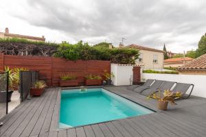einen Hinterhof mit einem Pool und einer Holzterrasse in der Unterkunft Baraka in Salon-de-Provence