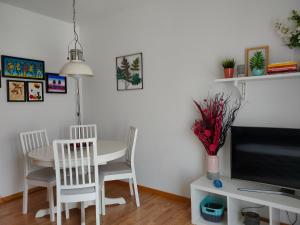 a dining room with a table and chairs and a tv at Apartamento da Giesta in Rio Tinto