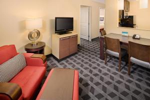 TownePlace Suites by Marriott Fayetteville N / Springdale في جونسون: غرفة في الفندق مع أريكة وطاولة وتلفزيون