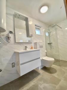 y baño con lavabo, aseo y ducha. en Apartments Šimić, en Trogir