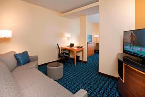 a hotel room with a couch and a flat screen tv at Fairfield Inn & Suites by Marriott Denver Tech Center/ South in Highlands Ranch