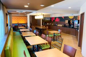 a restaurant with wooden tables and chairs and a bar at Fairfield Inn & Suites by Marriott Denver Tech Center/ South in Highlands Ranch