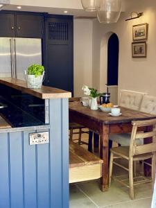 uma cozinha com uma mesa de madeira e uma sala de jantar em Beautiful 3 bed cottage in Lymington. Perfectly located for Coast and New Forest em Lymington