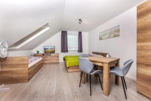 1 dormitorio con 1 cama, mesa y sillas en Malta apartamenty i pokoje, en Karwia