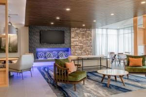eine Lobby mit Stühlen, Tischen und einem TV in der Unterkunft Fairfield Inn & Suites by Marriott Wenatchee in Wenatchee