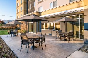 un patio con tavoli, sedie e ombrelloni di Fairfield Inn & Suites by Marriott Wenatchee a Wenatchee