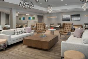 uma sala de estar com sofás e cadeiras e uma mesa em Residence Inn Doral Mall Area em Doral