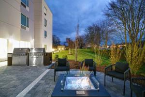 een patio met een tafel en stoelen en een gebouw bij TownePlace Suites by Marriott Fall River Westport in Lakeside