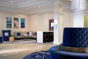 sala de estar con silla azul y sofá en Milwaukee Marriott West, en Waukesha