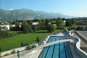 a swimming pool with a slide in a park at Four Points by Sheraton Panoramahaus Dornbirn in Dornbirn