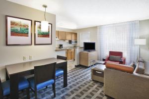 a living room with a table and a couch and a kitchen at TownePlace Suites by Marriott Brookfield in Brookfield