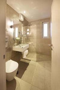 a bathroom with a toilet and a sink at Olive Family Suites - Hotel & Resort Adria Ankaran in Ankaran