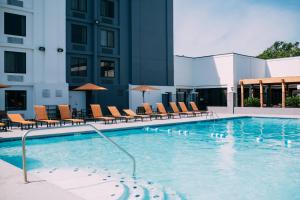 una piscina con sillas y un edificio en Courtyard by Marriott Gulfport Beachfront, en Gulfport
