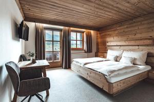 sypialnia z łóżkiem i biurkiem w pokoju w obiekcie Hotel Chalets Grosslehen w mieście Fieberbrunn