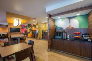 a restaurant with tables and chairs and a bar at Fairfield Inn & Suites Dallas Lewisville in Lewisville