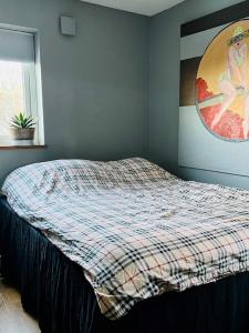 a bedroom with a bed with a plaid blanket on it at Modern house in Nacka Stockholm in Lännersta