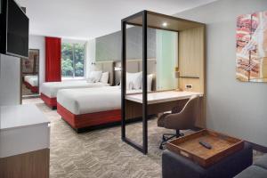 ein Hotelzimmer mit 2 Betten und einem Schreibtisch in der Unterkunft SpringHill Suites by Marriott Atlanta Northwest in Atlanta