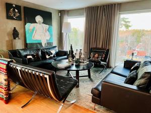 a living room with black leather furniture and a table at Modern house in Nacka Stockholm in Lännersta