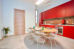 パレルモにあるKMC suites - Purpleのキッチン(木製テーブル、赤いキャビネット付)