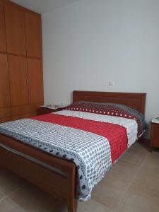 Plátonas的住宿－Villa Nafsika，一间卧室配有一张带红色和白色棉被的床