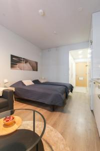 a bedroom with a bed and a coffee table at City Apartment Myllyntupa in Kuopio
