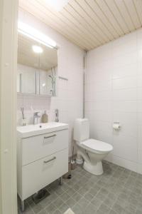 a white bathroom with a toilet and a sink at City Apartment Myllyntupa in Kuopio