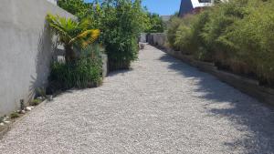 a gravel alley with plants on the side of a building at Angers Green Lodge - Cosy Studio in Angers