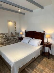 a bedroom with a large bed with two tables and two lamps at Thea in Symi