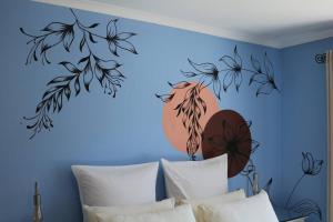a bedroom with a blue wall with a mural of leaves at Sunset Cottage - Cheerful 1 Bedroom Cottage in Barrydale