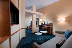 チャールストンにあるFairfield Inn and Suites Charleston North/University Areaのソファとデスクが備わるホテルルームです。