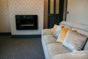 uma sala de estar com um sofá e uma lareira em Ainslie St by Prestige Properties SA em Barrow in Furness