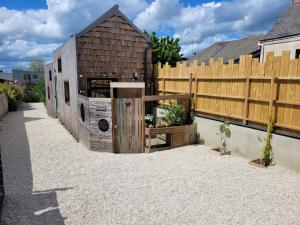 une grange en bois dans une cour avec une clôture dans l'établissement TINY HOUSE Cosy 1 - Angers Green Lodge, à Angers