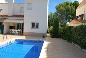 a swimming pool in a yard next to a house at Villa Cala Llobeta 4C-11 in Calafat