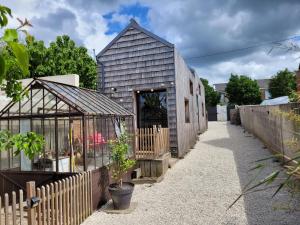 a barn conversion with a greenhouse and a house at Tiny House Cosy 2 - Angers Green Lodge in Angers