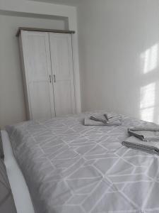 Cama blanca en habitación con armario en Jaekels Ferienwohnung en Görlitz