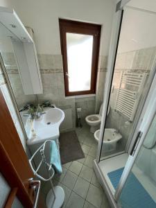 y baño con 2 aseos, lavamanos y ducha. en Victoria's House en Rapallo