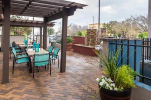 a patio with a table and chairs on a roof at SpringHill Suites by Marriott Houston Baytown in Baytown